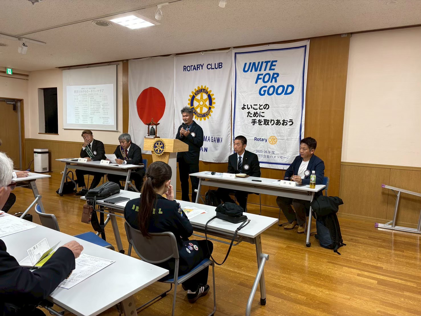 演台で卓話を行う会員と通常例会の参加者